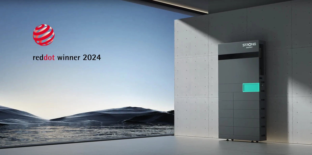 iSolarPro Strong Energy Energiespeicher in dunkelgrauer Ausführung mit Red Dot Winner 2024 Auszeichnung und moderner Architektur im Hintergrund für Photovoltaik-Systeme